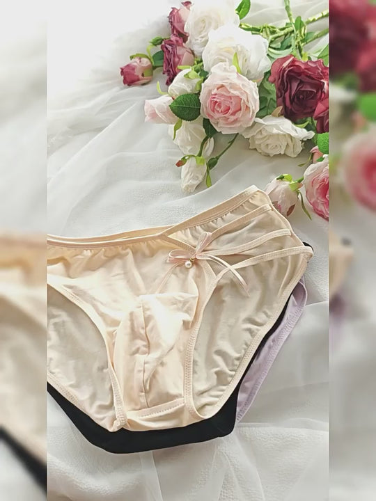 plain cotton femboy panties with a strappy cut-out and bow at the hip shown from several angles